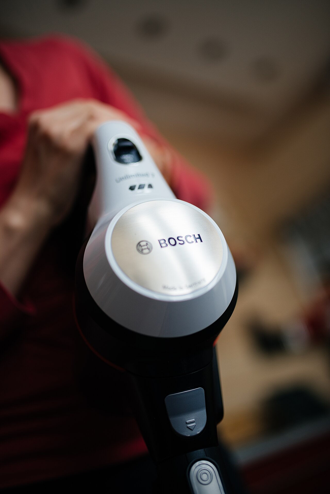 Close-up of a cordless handheld vacuum at work in a living room